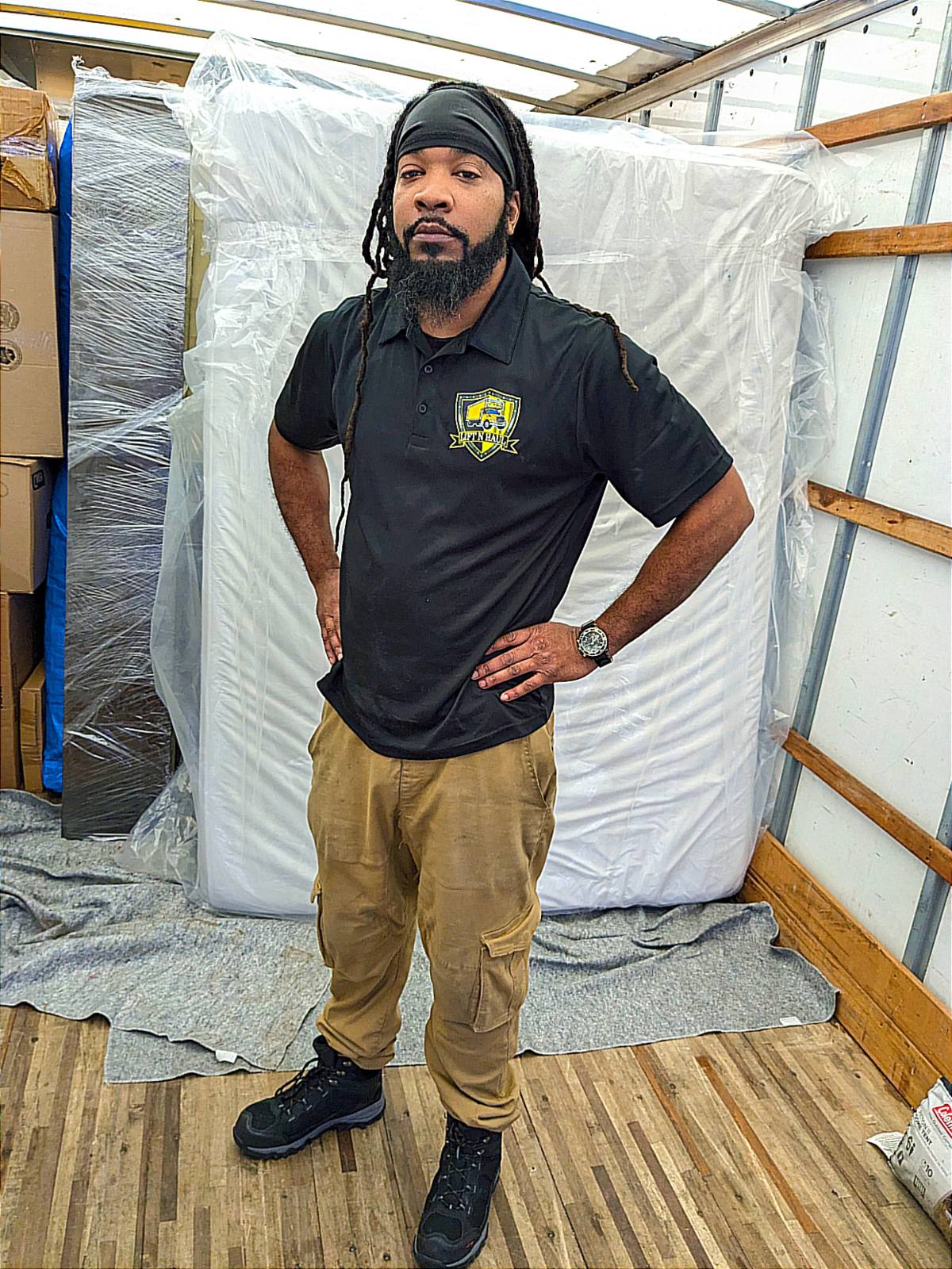 LiftNHaul team member in branded uniform with professionally wrapped furniture